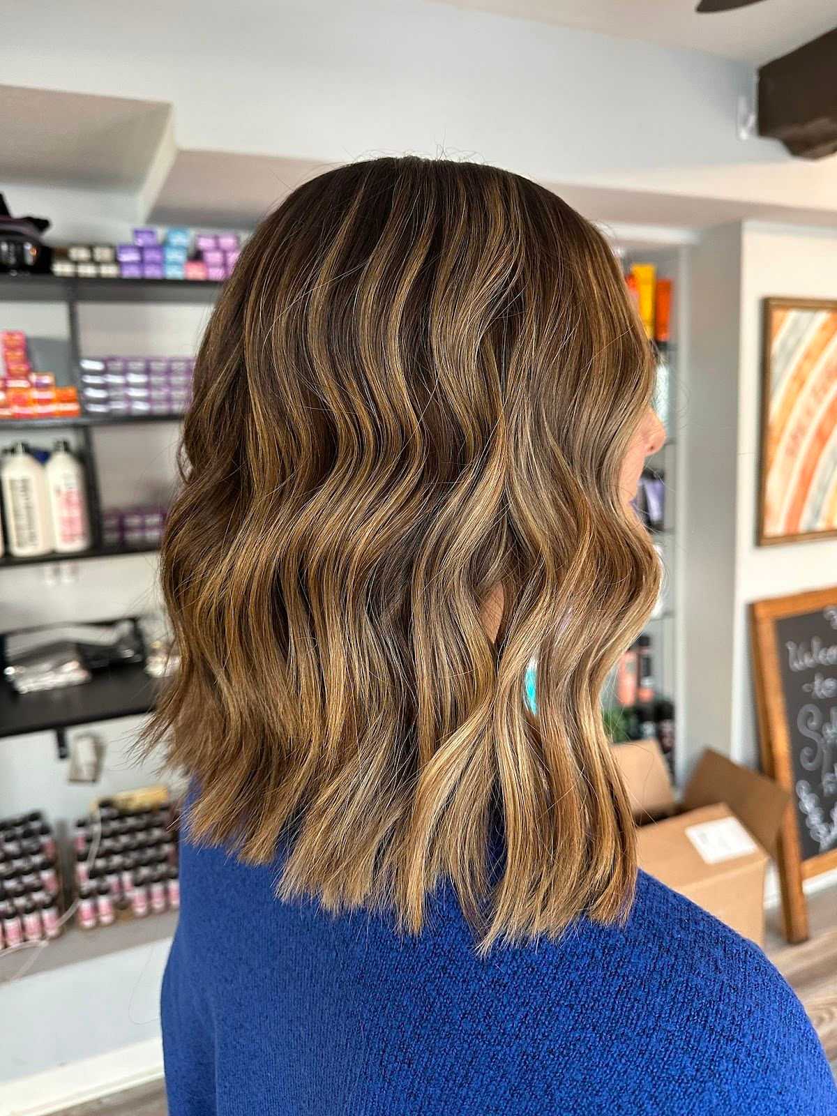 Wavy brown hair with highlights in a salon setting.